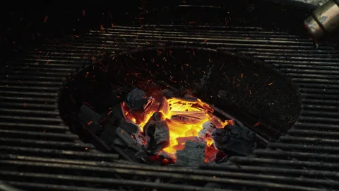Glowing Charcoal Briquettes Igniting in Backyard Barbecue Stock Footage 340888038