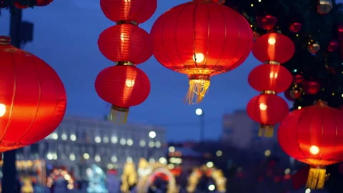 Glowing Chinese red lanterns hang against a soft evening sky Video stock 328501304