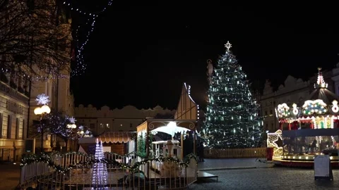 Glowing christmas tree and carousel in lively winter square Stock Footage 325073745
