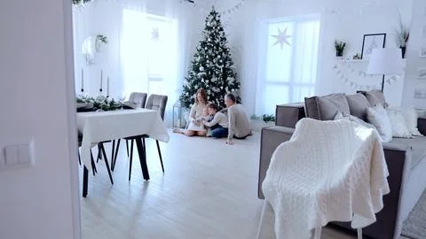 Glowing Christmas tree serves as backdrop to large family celebrating together Stock Photos