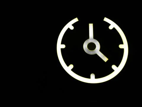 A glowing clock icon with white light against a black background Stock Illustration