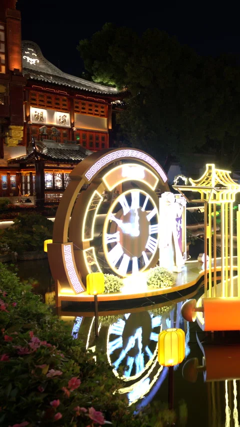 Glowing clock lantern floating on pond at night in SHANGHAI China Vidéo 344953172