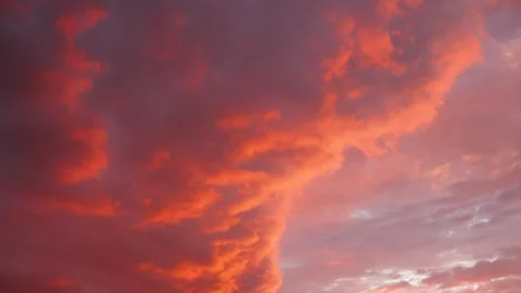 Glowing clouds transform the sky into a canvas of orange and purple hues Stock Footage 338023930