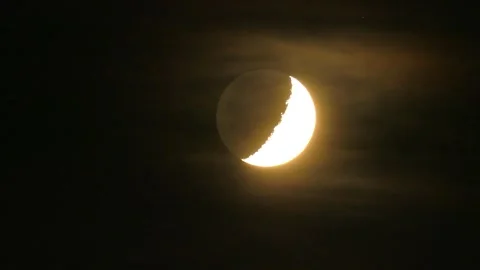 Glowing crescent moon illuminates the night sky surrounded by wispy clouds Stock Footage 321498654