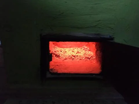Glowing Ember Inside a Rustic Wood Stove Stockfoto's