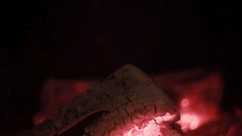 Glowing ember log burning in fireplace - cozy warm fire macro texture Video stock 330202383