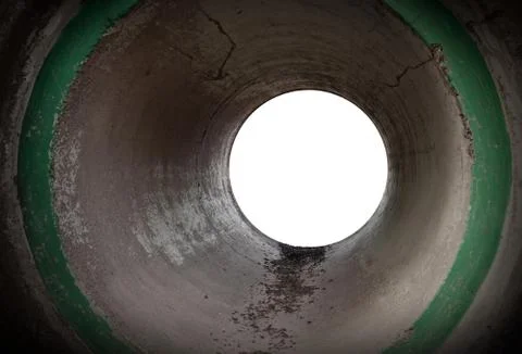 Glowing end of an empty round concrete tunnel interior Stock Photos