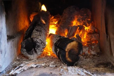 Glowing fire in a rustic stove Stock Photos