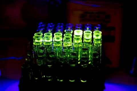 Glowing fluorescent compound collected from column chromatography in a chemis Stock Photos