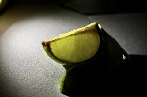 Glowing Fresh Lime Slice in Dramatic Spotlight Macro Close-Up 库存照片