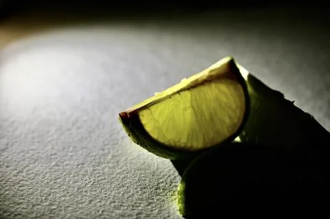 Glowing Fresh Lime Slice in Dramatic Spotlight Macro Close-Up 写真素材