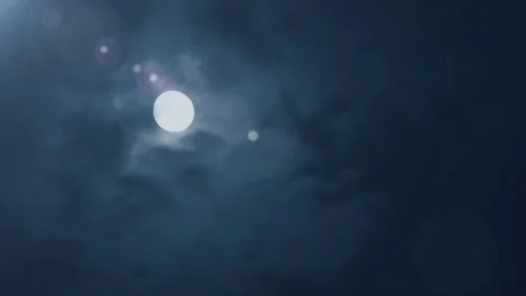 Glowing full moon shines brightly through dark blue cloudy night sky background Stock Footage 340943305