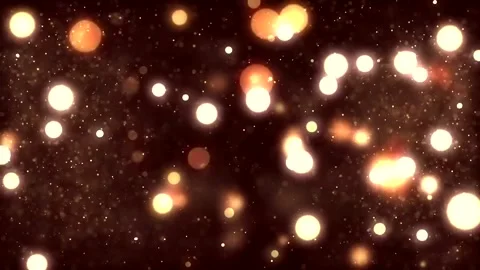Glowing golden light particles float against dark background in festive ambiance Stock Footage 222033826