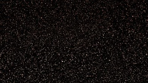 Glowing golden-orange particles scattered across dark background Stock Illustration