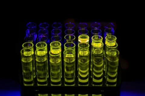 Glowing green compound solution collected from column chromatography in multi Stock Photos
