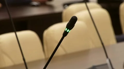A glowing green microphone against a backdrop of chairs Stock Footage 324766511