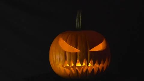 Glowing Halloween Pumpkin on Black Background Stock Footage 327431361