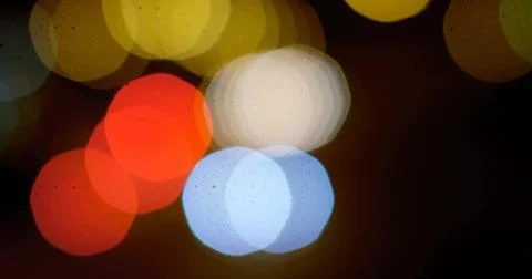 Glowing hexagonal bokeh lights overlapping against dark urban backdrop, creating Stock Photos