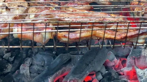 Glowing hot coals burn intensely in a barbecue grill outdoors on a summer day. T Stock-Footage 310846498