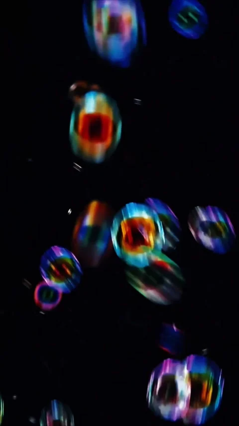Glowing iridescent liquid bubbles floating in dark space for abstract background 스톡 동영상 347692611
