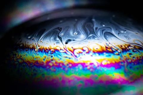 Glowing iridescent soap bubble edge macro against dark background Stock Illustration
