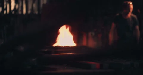 Glowing iron with blacksmith working in background Stock Footage 61353685