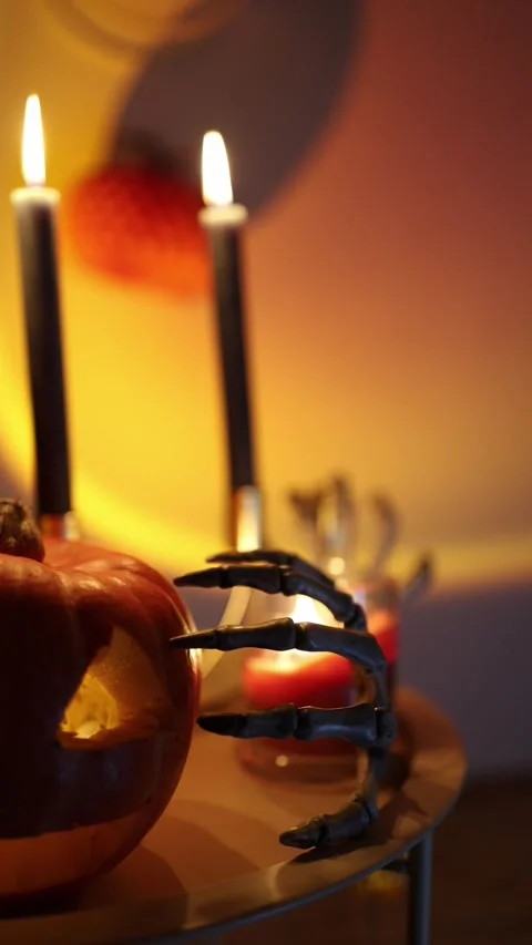 Glowing jack o lantern becomes a centerpiece for a candlelit Halloween party Stock Footage 345493717