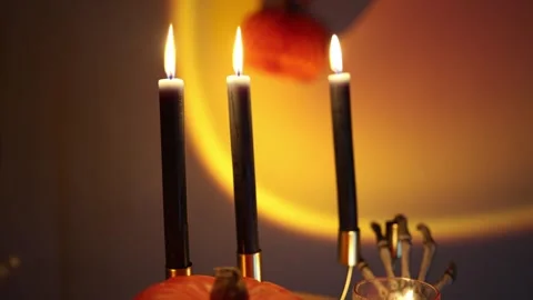 Glowing jack o lantern with black candles creates classic Halloween decor Stock Footage 346147569