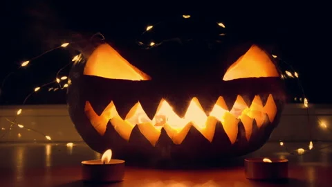 Glowing Jack-O-Lantern on Halloween Night With Fairy Lights Stock Footage 277246233