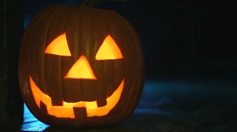 Glowing jack-o-lantern sitting on a porch with eerie smoke, ready for Halloween Stock Footage 30561615