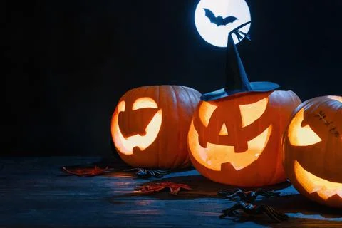 Glowing Jack-O'-Lanterns With Witch Hat Under Full Moon Stock Photos