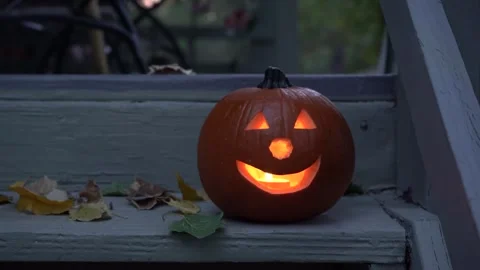 A glowing JackOLantern pumpkin on the porch steps in Fall Stock Footage 252769376