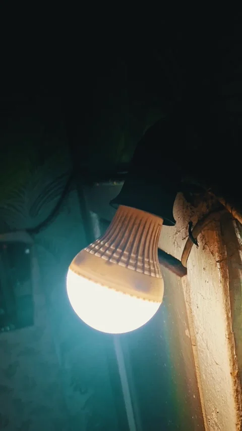 Glowing LED Light Bulb in Dark Grunge Basement Setting Stock Footage 322534475