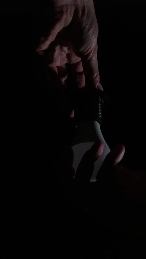 Glowing Led Light Bulb Hanging in Dark with Dramatic High Contrast Lighting Stock Footage 334136532