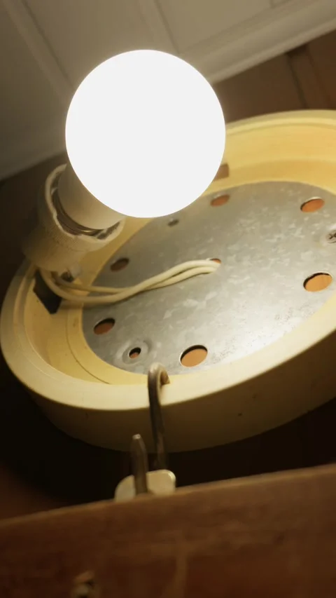 Glowing Led Light Bulb Shining in Round Ceiling Fixture Inside Basement Stock Footage 335641558
