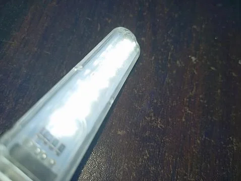 Glowing LED strip transparent flash light with brown texture background Foto stock