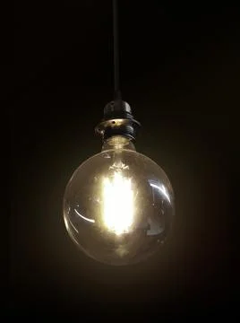 Glowing light bulb on dark background Stock Photos