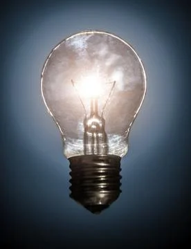 Glowing light bulb on dark background Stock Photos