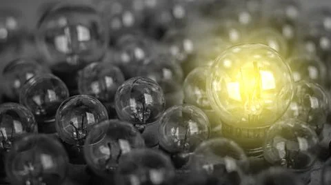 Glowing light bulb on the gray background. Stockfoto's