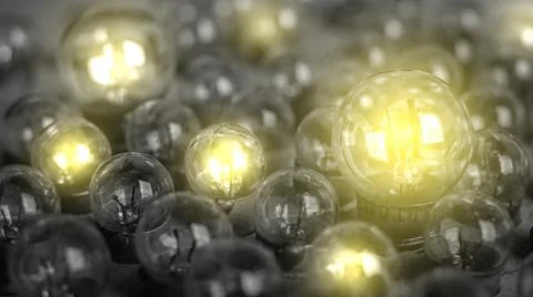 Glowing light bulb on the gray background. Stock Photos