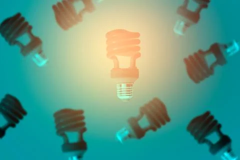 Glowing light bulb levitating over blue background and black bulbs Stock Photos