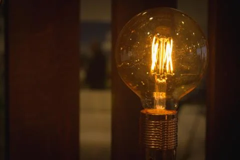 A glowing light bulb. Light bulb on a dark background with copy space. Stock Photos