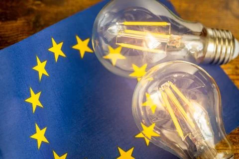 A glowing light bulb lying in the middle of the European Union flag, Stock Photos