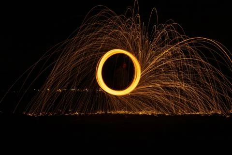 Glowing light extending its sparks into the air as it is rapidly spinning Stock Photos