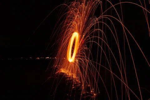 Glowing light extending its sparks into the air as it is rapidly spinning Stock Photos