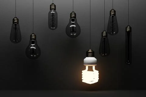 Glowing light fluorescent bulb LED isolated on black concrete background surr Stock Photos