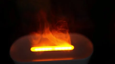 Glowing Light with Smoke in Dark Background, Close-up of an orange glowing .. Видео 304875800