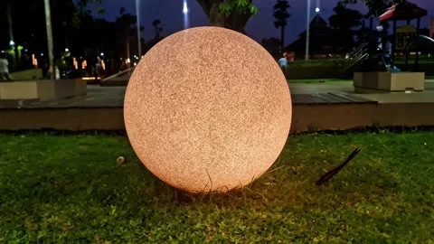 Glowing Moon Orb Garden Light on Green Grass Round Sphere Outdoor Lamp Stock Footage 332923880