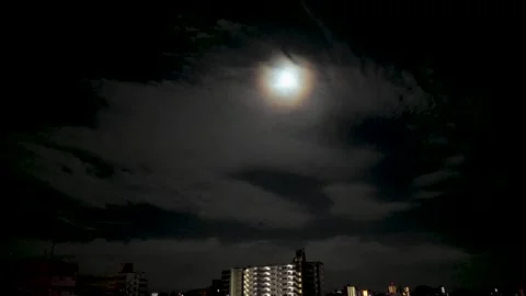 Glowing Moon Through Clouds in Night Sky Stock Footage 335568169