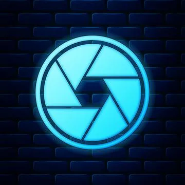 Glowing neon Camera shutter icon isolated on brick wall background. Vector Illustrazione stock